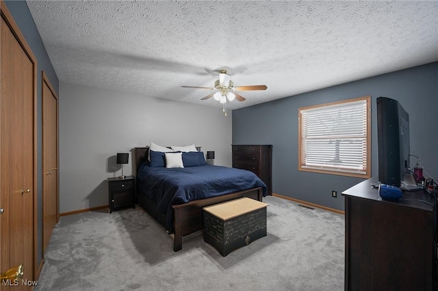 carpeted bedroom featuring ceiling fan, a textured ceiling, and a closet