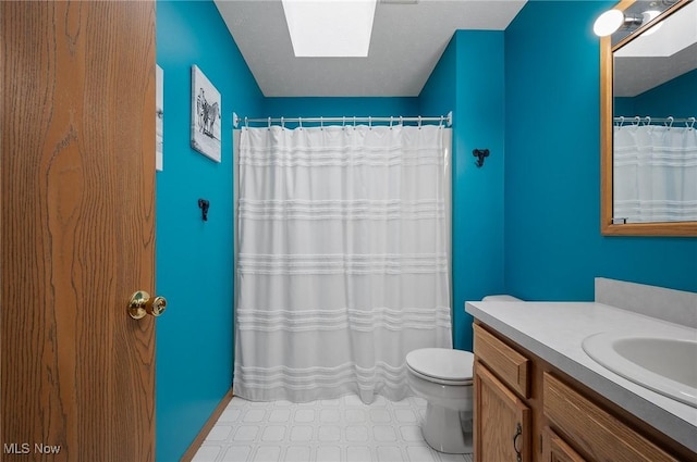 bathroom featuring toilet, a skylight, and vanity