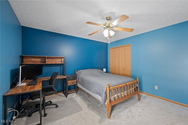 carpeted bedroom featuring ceiling fan, a textured ceiling, and a closet