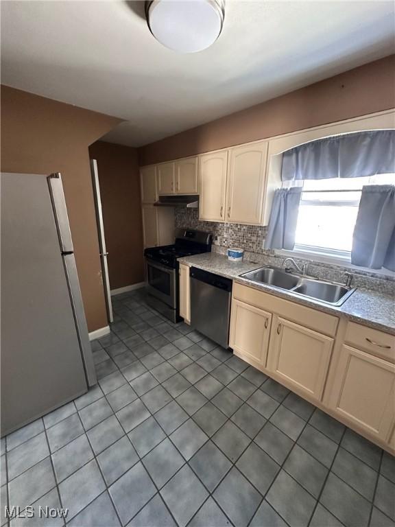 kitchen featuring sink, appliances with stainless steel finishes, tasteful backsplash, and tile patterned flooring