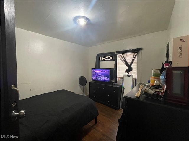 bedroom with dark hardwood / wood-style flooring