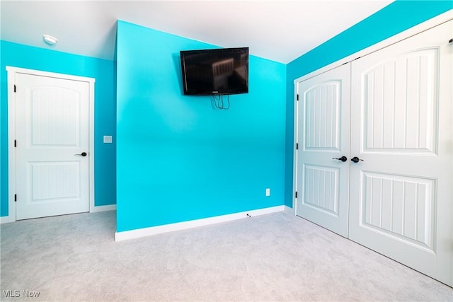 unfurnished bedroom featuring light colored carpet and a closet