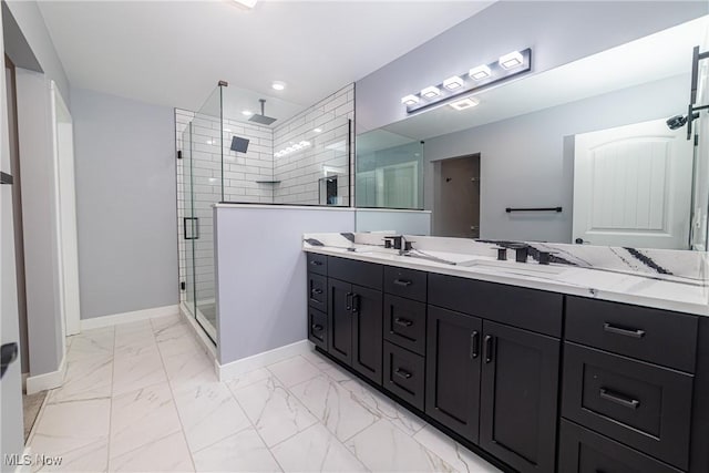 bathroom featuring a shower with shower door and vanity