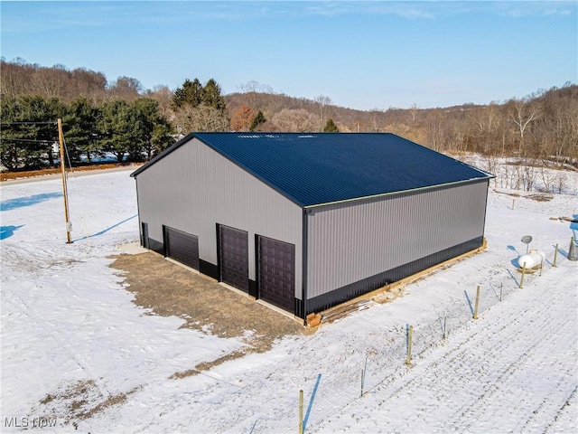 view of snow covered exterior with an outdoor structure and a garage