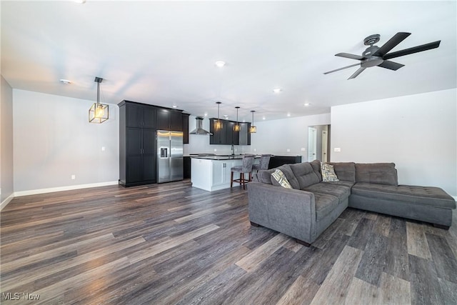 living room with ceiling fan, sink, and dark hardwood / wood-style floors