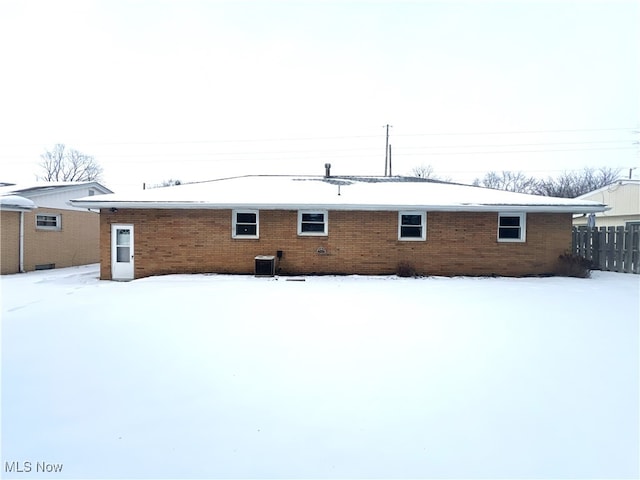 snow covered house with central air condition unit