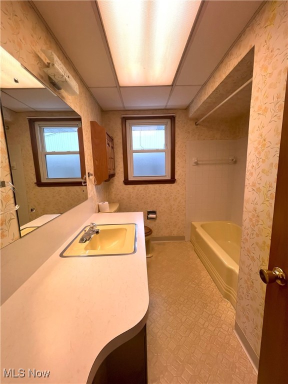 full bathroom with shower / washtub combination, a paneled ceiling, toilet, and vanity