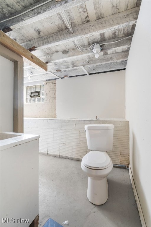 bathroom featuring toilet and concrete flooring