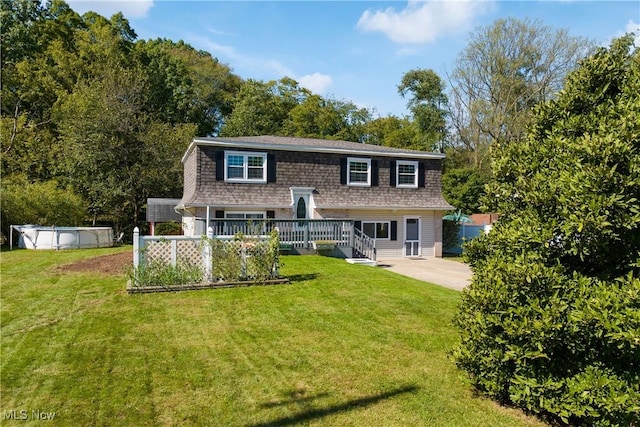 rear view of property with a lawn and a swimming pool side deck