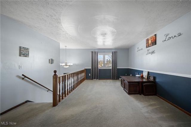 interior space featuring carpet floors, a textured ceiling, and a chandelier