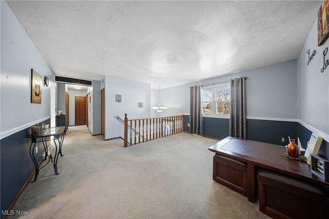 office area with a notable chandelier, light colored carpet, and a textured ceiling