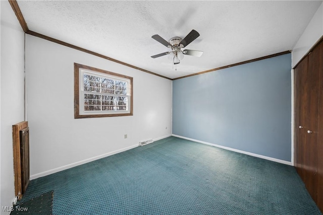 carpeted spare room featuring ceiling fan, a textured ceiling, and crown molding