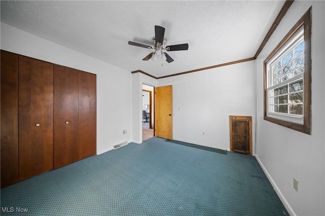 unfurnished bedroom featuring a textured ceiling, carpet floors, a closet, and ceiling fan