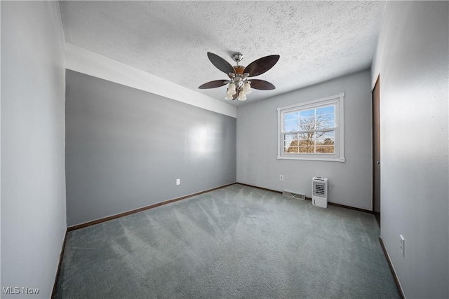 carpeted empty room featuring ceiling fan and a textured ceiling