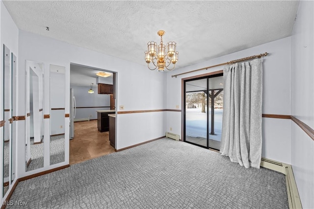 spare room with a baseboard radiator, a textured ceiling, and a chandelier