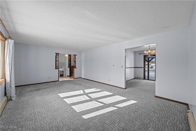 unfurnished room with light colored carpet, a chandelier, and baseboard heating