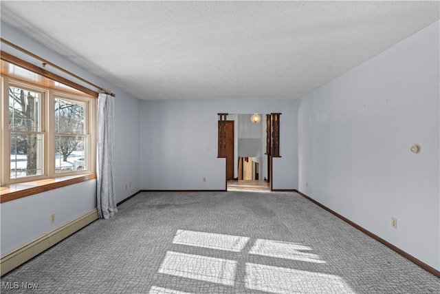 spare room with a baseboard heating unit, carpet floors, and a textured ceiling