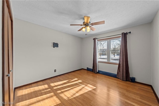 spare room with hardwood / wood-style floors, a textured ceiling, and ceiling fan