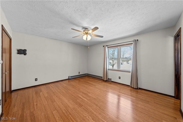 empty room with a textured ceiling, light hardwood / wood-style flooring, and ceiling fan