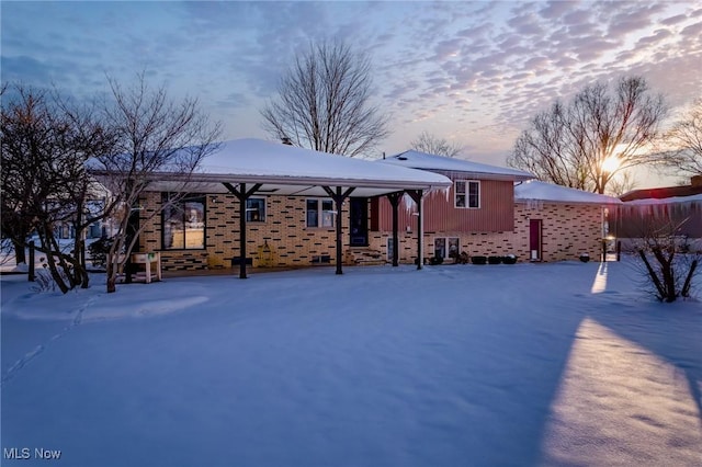 view of snow covered back of property