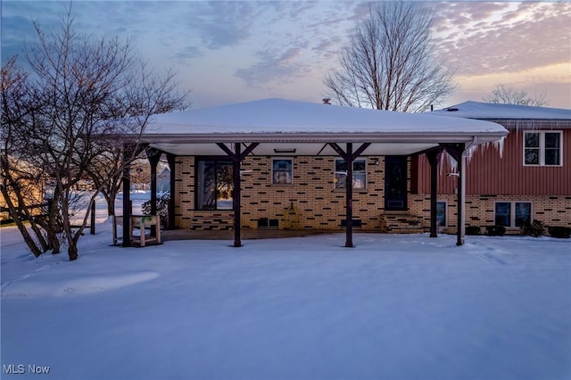 view of snow covered back of property