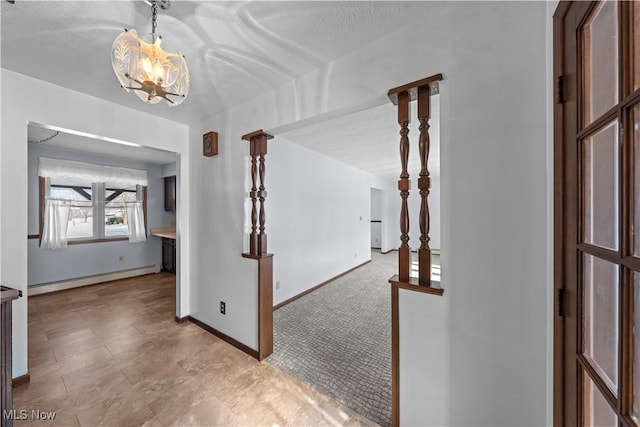 hallway with baseboard heating, light colored carpet, a textured ceiling, and a chandelier