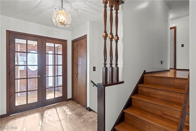 entryway with a notable chandelier and french doors