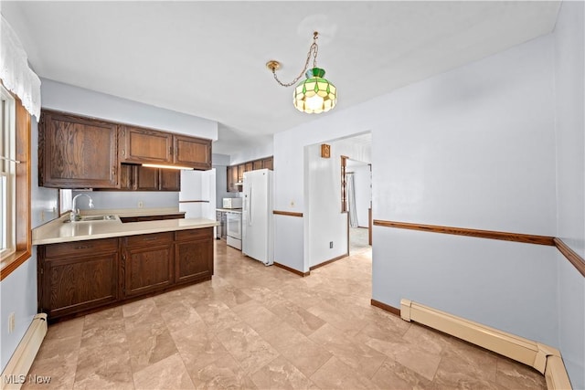 kitchen with a baseboard radiator, white appliances, dark brown cabinetry, and sink