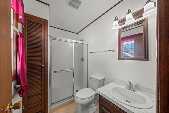 bathroom featuring toilet, an enclosed shower, tile patterned floors, and vanity