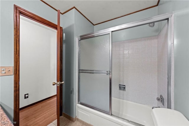 bathroom featuring bath / shower combo with glass door and tile patterned flooring