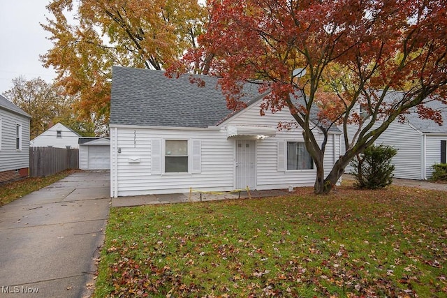 view of front facade featuring a garage, a front lawn, and an outdoor structure