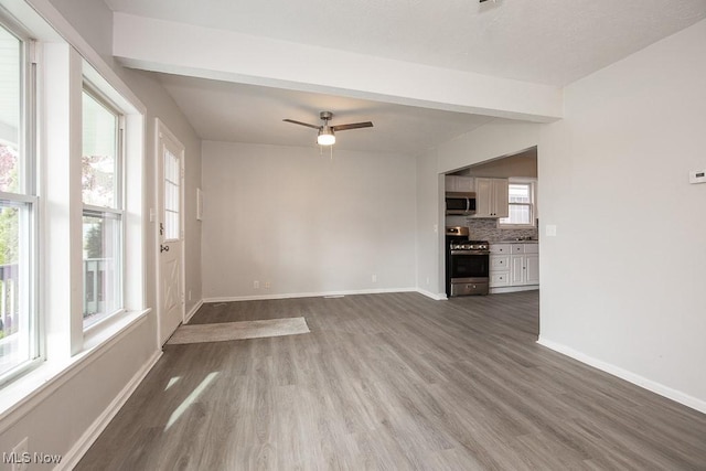 unfurnished living room with hardwood / wood-style flooring, ceiling fan, and a healthy amount of sunlight