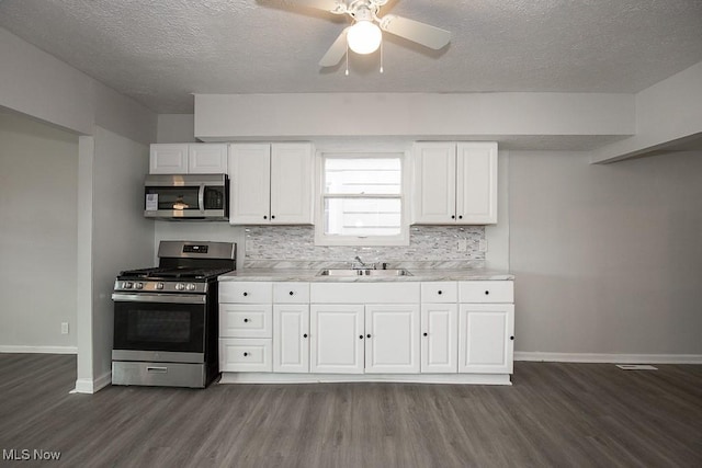 kitchen with sink, white cabinetry, backsplash, and stainless steel appliances