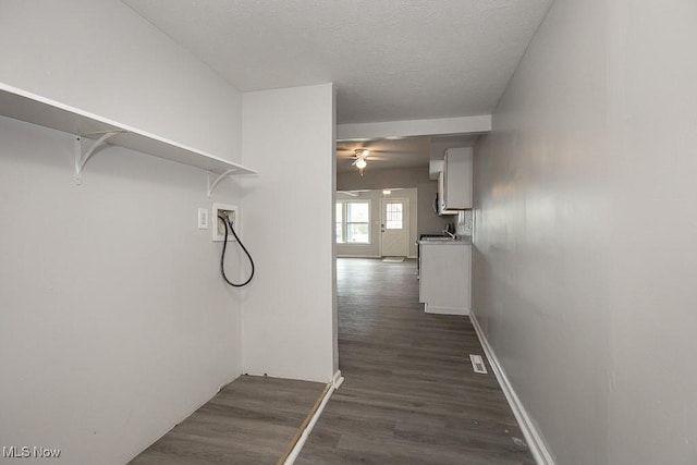 hallway with dark hardwood / wood-style floors and a textured ceiling