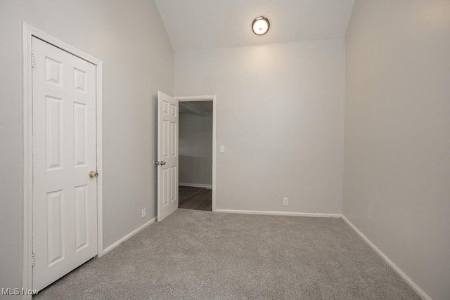 empty room with carpet flooring and vaulted ceiling