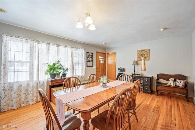 dining area featuring an inviting chandelier and light hardwood / wood-style floors