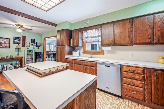 kitchen with ceiling fan, stainless steel dishwasher, a center island, and sink