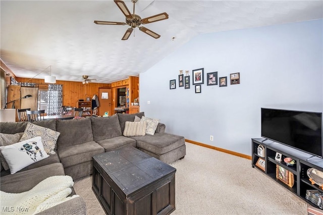 carpeted living room featuring ceiling fan, lofted ceiling, and wooden walls