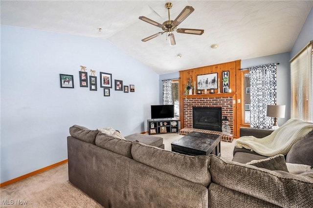 carpeted living room featuring vaulted ceiling, a fireplace, and ceiling fan