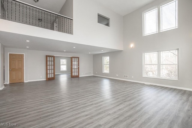 unfurnished living room featuring hardwood / wood-style flooring and a high ceiling