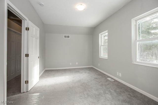 unfurnished bedroom with vaulted ceiling and carpet flooring