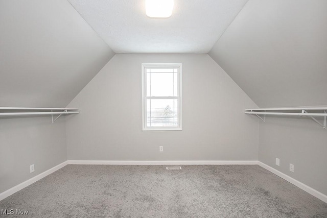 walk in closet featuring vaulted ceiling and carpet flooring