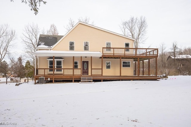 snow covered back of property featuring cooling unit and a porch