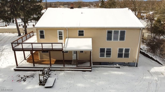 snow covered house with a wooden deck