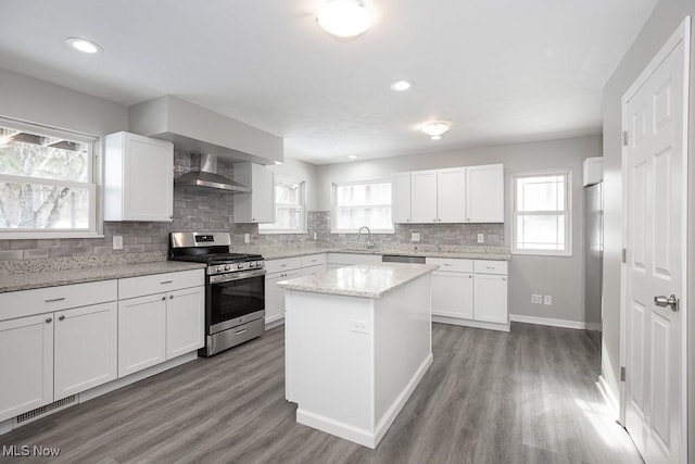 kitchen with sink, white cabinetry, gas stove, and light stone counters