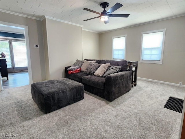 carpeted living room featuring ceiling fan and crown molding