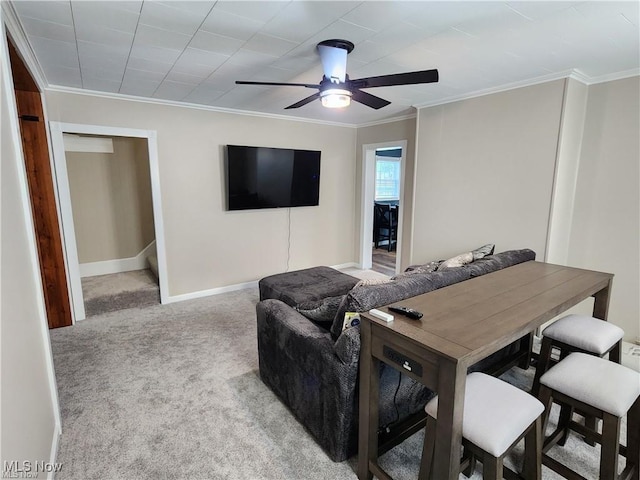 living room with ceiling fan, crown molding, and light carpet