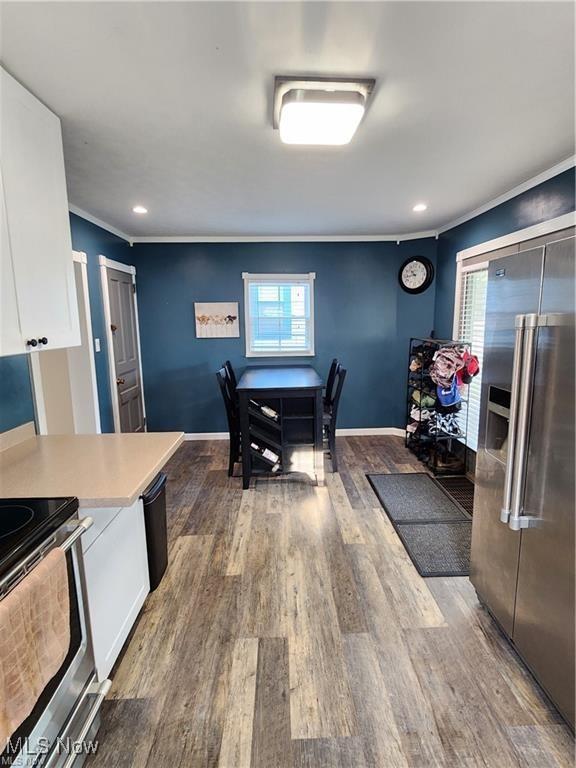 kitchen with ornamental molding, dark wood-type flooring, white cabinetry, and appliances with stainless steel finishes