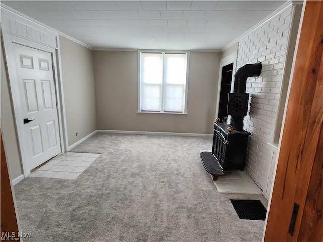 living room featuring a wood stove, ornamental molding, and light carpet