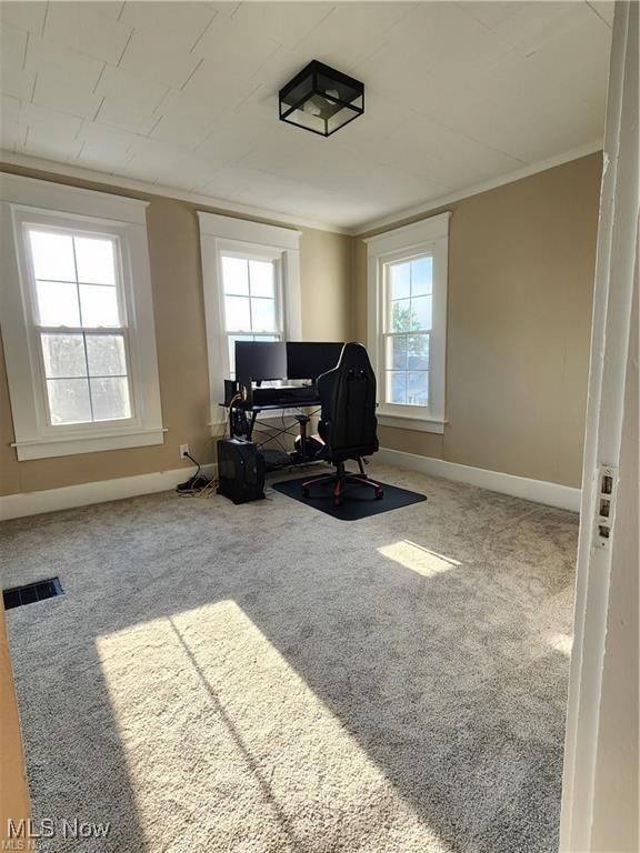 living area with a healthy amount of sunlight and ornamental molding